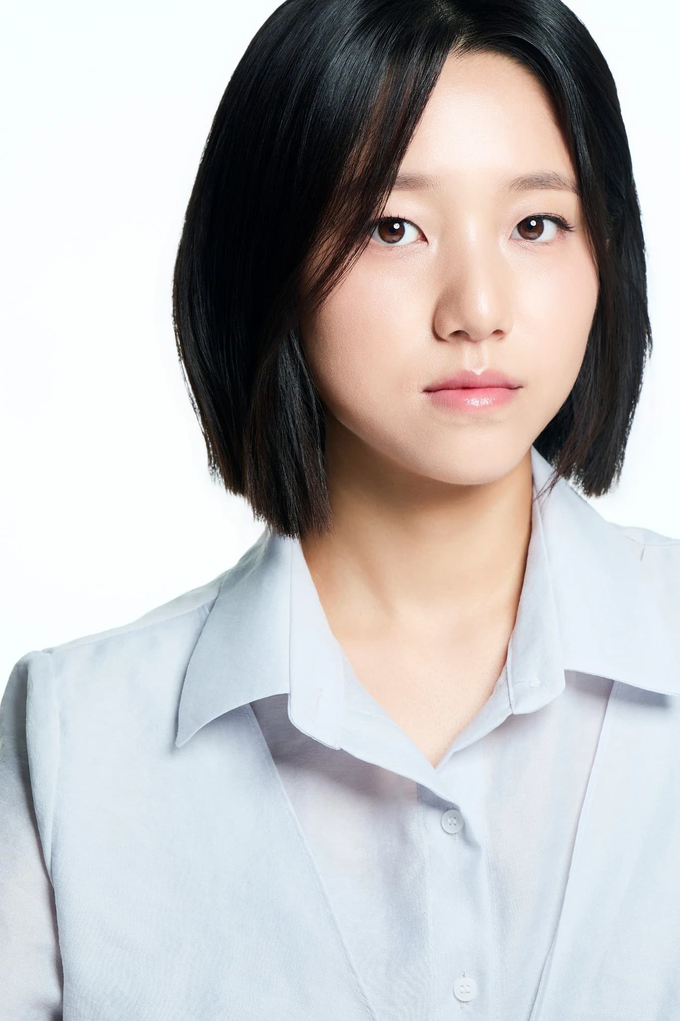 밝은 회색 셔츠를 입고 정면을 응시하는 인물 프로필